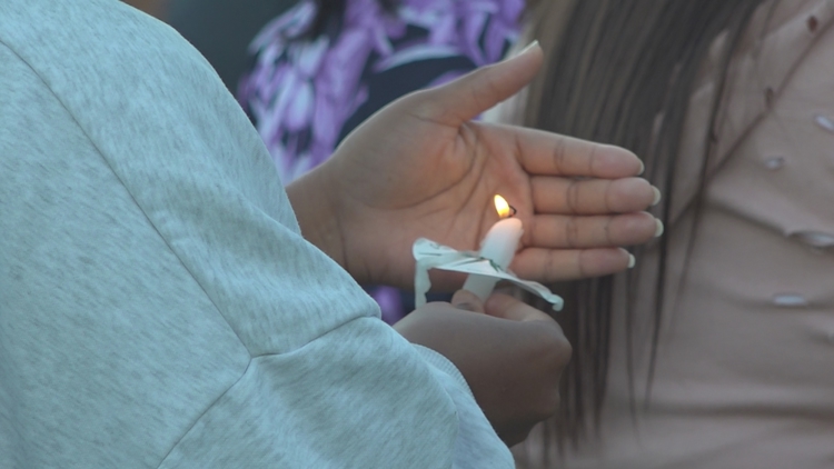 Candlelight vigil attendees holding candles at Rosa Parks Square in Macon, Georgia, for Domestic Violence Awareness Month.